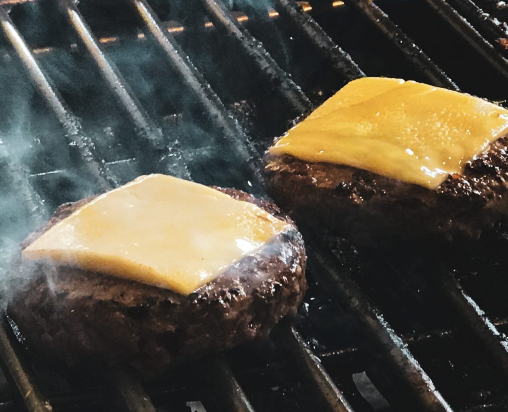 2 cheeseburgers on a bbq grill