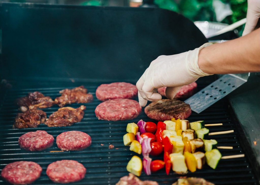 hong kong bbq catering private chefs hands over a bbq grill with varied food items