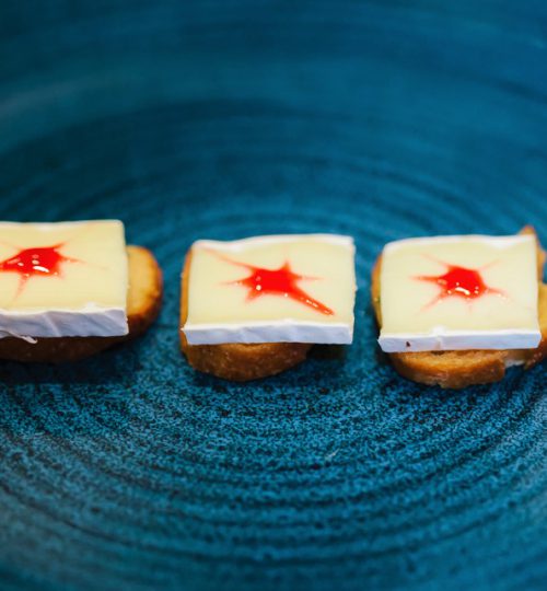 colourful red and white canapes on a black plate from private chef tom burney of hong kong personal chef