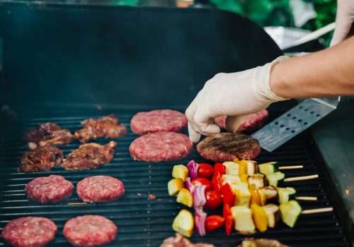 hong kong bbq catering private chefs hands over a bbq grill with varied food items